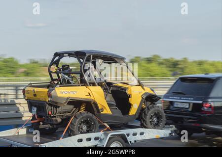 Pologne, Varsovie - 02 juin 2021 : Quad bike avec toit, sur une remorque de voiture. VTT avec toit. Le tourisme familial. Transport de l'ATV Banque D'Images