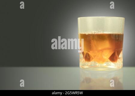 Verre embué avec des gouttes d'eau et whisky avec de la glace. Un verre de whisky sueur avec de la glace sur la table et un espace de copie Banque D'Images