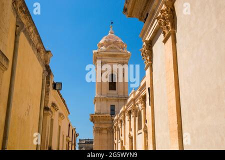 Noto, Syracuse, Sicile, Italie. Vue le long de la rue étroite ensoleillée jusqu'au clocher de la cathédrale baroque de San Nicolò. Banque D'Images