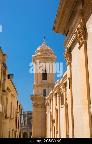 Noto, Syracuse, Sicile, Italie. Vue le long de la rue étroite ensoleillée jusqu'au clocher de la cathédrale baroque de San Nicolò. Banque D'Images