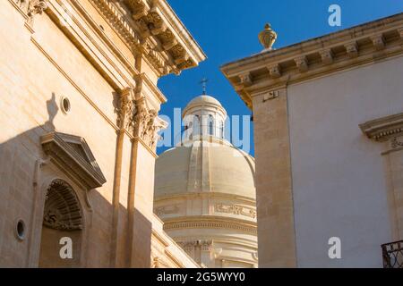 Noto, Syracuse, Sicile, Italie. Vue à angle bas par une ouverture étroite sur le dôme reconstruit de la cathédrale baroque de San Nicolò. Banque D'Images