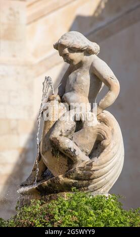 Noto, Syracuse, Sicile, Italie. Ancienne fontaine en pierre de la Piazza dell'Immacolata, représentant la figure sculptée d'un garçon à cheval sur un dauphin. Banque D'Images