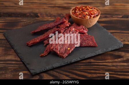 Une Pile de la charque chaude et épicée avec des flocons de piment rouge Banque D'Images