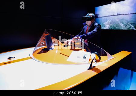 Un visiteur du congrès qui contrôle à distance un drone marin sur le stand Orange du Mobile World Congress, au cours du troisième jour de l'événement. Grâce à 5G, un bateau sans pilote situé dans le port de ValenciaÕs pouvait être contrôlé, avec presque aucune latence, depuis Barcelone, à environ 300km. Bien que le contrôle des drones et des véhicules à distance ne soit pas quelque chose de nouveau, le faire dans un environnement maritime présente un défi difficile en raison des interférences de la mer avec les ondes radio, et n'a pas été vu auparavant. L'utilisation d'un casque de réalité virtuelle et d'un simulateur de voile rend l'expérience plus imm Banque D'Images