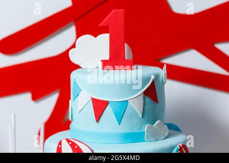 Bar à bonbons pour la fête d'anniversaire du garçon avec beaucoup de bonbons différents, pop-corn, boissons et grand gâteau. Décoration bleue, rouge et blanche, ballons o Banque D'Images