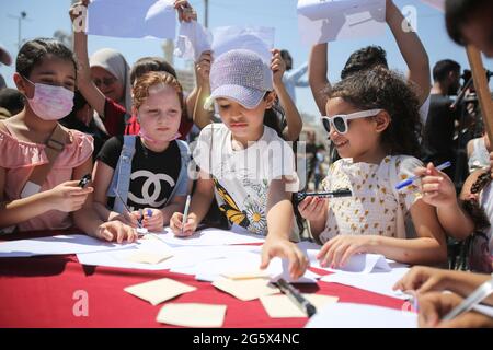 Gaza, Palestine. 30 juin 2021. Les enfants palestiniens ont vu écrire des messages qui disent "c'est notre droit de vivre en paix".au port de Gaza, les enfants ont inséré des messages à l'intérieur de bouteilles en plastique et les ont libérés dans la mer pour qu'ils puissent "racher le monde" dit un enfant. (Photo par Ahmed Zakot/SOPA Images/Sipa USA) crédit: SIPA USA/Alay Live News Banque D'Images