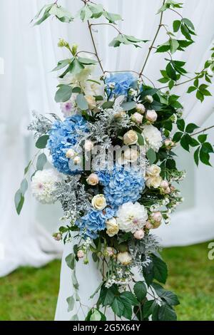 Décorations pour la cérémonie de mariage : décoration de près de l'arche, ornée de crysanthèmes, de roses, d'hortensias et de verdure. Beaucoup de fleurs en blanc et bleu Banque D'Images