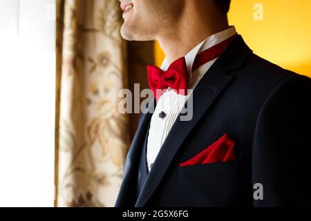 Jeune marié bleu foncé avec noeud rouge à pois et mouchoir dans la poche. Accessoires de mariage pour hommes Banque D'Images