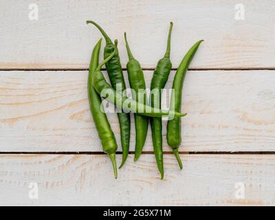 Plan de vue sur les piments verts sur un fond rustique et lambrissé de bois blanc. Banque D'Images