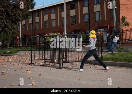 Bogota, Colombie. 29 juin 2021. Un démonstrateur jette des pierres et démêle la police anti-émeute de Colombie (ESMAD) alors que les gens de Fontanar - Suba à Bogota, Colombie ont protesté et affronté la police anti-émeute de Colombie (Escuadron Movil Antiperturbabios ESMAD) contre la visite du président colombien Ivan Duque Marquez à un parc où le métro de Bogota sera construit, Au milieu de deux mois de manifestations anti-gouvernementales contre le président Ivan Duque Marquez, inégalités et troubles de la police pendant les manifestations, le 29 juin 2021. Crédit : long Visual Press/Alamy Live News Banque D'Images