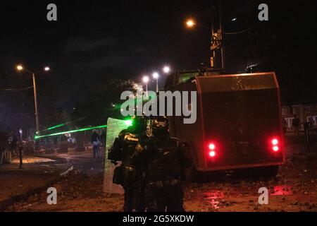 Bogota, Colombie. 29 juin 2021. Les policiers anti-émeutes de Colombie prennent la couverture d'un camion blindé anti-émeute alors que les gens de Fontanar - Suba à Bogota, Colombie ont protesté et affronté la police anti-émeute de Colombie (Escuadron Movil Antiperturbabios ESMAD) contre la visite du président colombien Ivan Duque Marquez dans un parc où le métro de Bogota sera construit, Au milieu de deux mois de manifestations anti-gouvernementales contre le président Ivan Duque Marquez, inégalités et troubles de la police pendant les manifestations, le 29 juin 2021. Crédit : long Visual Press/Alamy Live News Banque D'Images