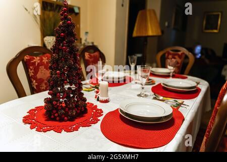 Dîner de Noël. Une table à manger décorée avec des verres à champagne et un arbre de noël lors de la fête de Noël à l'intérieur d'une maison Banque D'Images