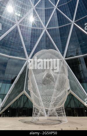 Sculpture Wonderland par Jaume Plensa à Calgary, Canada avec un gratte-ciel en arrière-plan. Banque D'Images