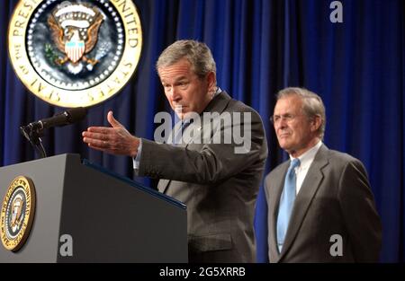 Arlington, États-Unis d'Amérique. 05e octobre 2001. Le président des États-Unis George W. Bush fait des remarques avant de signer H.R. 1588, le National Defense Authorization Act de l'année fiscale 2004 au Pentagone à Arlington, en Virginie, le 24 novembre 2003. Donald Rumsfeld, le secrétaire à la Défense des États-Unis, regarde de droite. Crédit : Ron Sachs/CNP/Sipa USA crédit : SIPA USA/Alay Live News Banque D'Images