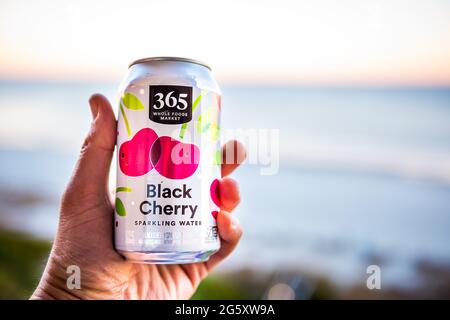 Myrtle Beach, États-Unis - 3 février 2021 : gros plan d'une boîte en aluminium pour Whole Foods 365 seltzer à saveur de cerise noire avec main Banque D'Images