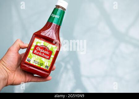 Nellysford, États-Unis - 29 avril 2021 : gros plan de l'affiche pour ketchup et contenant à la main une bouteille de marque de marque privée biologique de Trader Joe's. Banque D'Images