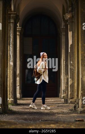 REDHEAD Tourisme destination de voyage femelle visite de l'ancienne place abandonnée en vacances. Belle femme marchant pendant les vacances d'été, temps froid à l'extérieur. Banque D'Images