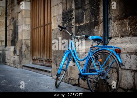 vélo bleu appuyé contre le mur d'une vieille église Banque D'Images