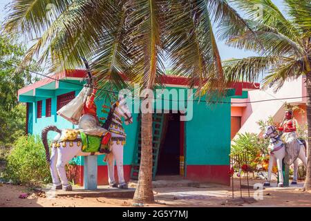 Bâtiment à un étage peint dans des couleurs vives avec d'énormes statues de figures anciennes à cheval, Puducherry (Pondicherry), Tamil Nadu, Inde Banque D'Images