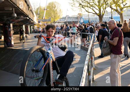 Les garçons font des cascades à vélo tandis que les touristes regardent sur Southbank Skate Space à Londres, Royaume-Uni Banque D'Images