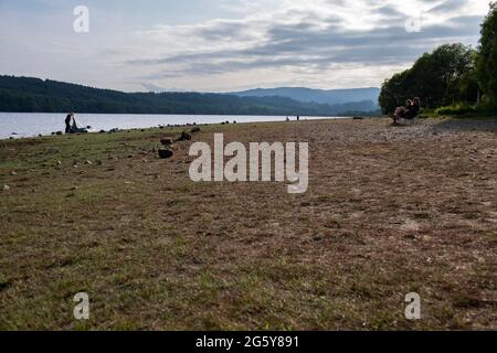 Loch Venachar, Loch. Lomonnd et Trossachs National Park, Écosse, Royaume-Uni. 30 juin 2021. PHOTO : une vue en grand angle de la plage de galets et de pierre sur le Loch Venachar, qui est normalement sous quelques pieds d'eau, est exposée en raison de la diminution de l'alimentation en eau utilisée. Il ne devrait pas y avoir de plage sur cette partie du loch, mais les gens peuvent être vus en utilisant cette plage de make Shift pour prendre le soleil en soirée. Crédit : Colin Fisher/Alay Live News Banque D'Images