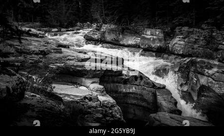 Noir et blanc photo de la rivière Maligne qui entre dans le canyon Maligne en amont du premier pont dans le parc national Jasper des montagnes Rocheuses, en Alberta Banque D'Images