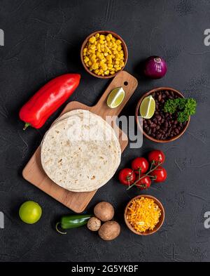 Préparation de la cuisson des tacos végétariens avec des champignons, des haricots, des poivrons, du maïs et du fromage. Banque D'Images