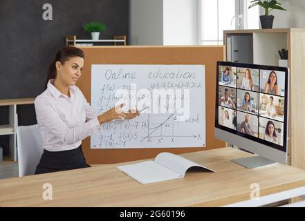 Jeune professeur de mathématiques donne des cours avec webcam aux étudiants, l'éducation en ligne à distance apprentissage. Banque D'Images