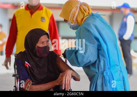 Indonésie. 1er juillet 2021. Une femme reçoit une injection du vaccin Sinovac COVID-19 lors d'une vaccination de masse au stade Patriot Candrabaga à Bekasi, Jawa Barat, Indonésie, jeudi 1er juillet, 2021. Le quatrième pays le plus peuplé au monde, a vu les infections à COVID-19 s'envolée au cours des dernières semaines, ce qui a mis la pression sur les hôpitaux, y compris dans la capitale, où la plupart des lits d'hôpitaux sont pleins. (Photo de Ahmad Soleh/Sipa USA) crédit: SIPA USA/Alay Live News Banque D'Images