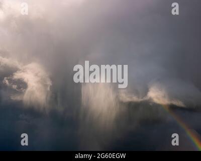 Nuages de tempête sombres et lourds avec un arc-en-ciel sur le bord Banque D'Images