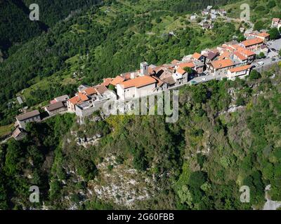 VUE AÉRIENNE. Village médiéval perché sur une longue et étroite crête de calcaire au-dessus de la vallée de la Vésubie. Alpes-Maritimes, France. Banque D'Images