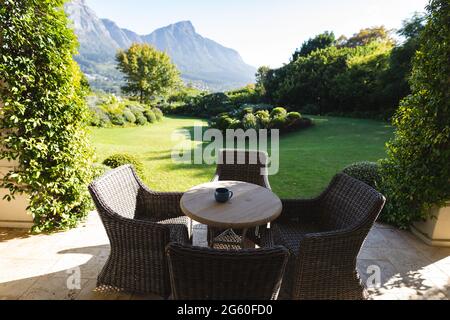 Vue générale sur la table et les chaises en osier sur la terrasse avec vue imprenable sur la campagne des montagnes Banque D'Images