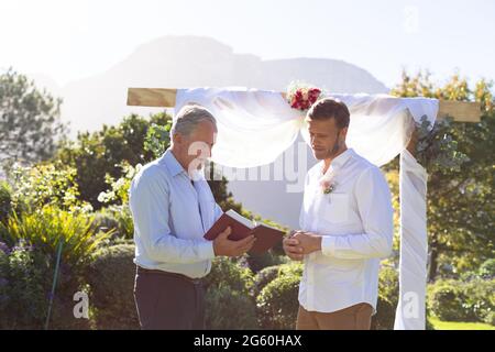Marié caucasien et parlant avec un officiel de mariage Banque D'Images