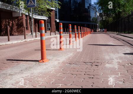 Borne orange avec bandes de peinture réfléchissantes sur la route. Embouteillage. Signalisation routière. Sécurité routière. Limite de vitesse. Rue vide. Banque D'Images