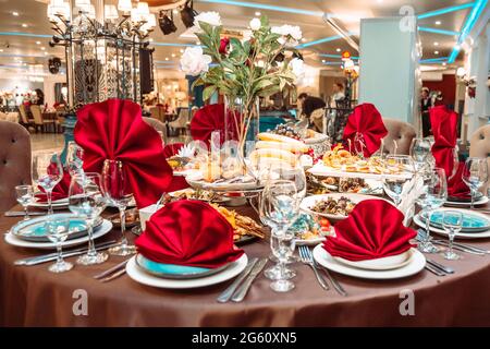 une table dans un restaurant avec de la nourriture et des serviettes rouges. Banque D'Images