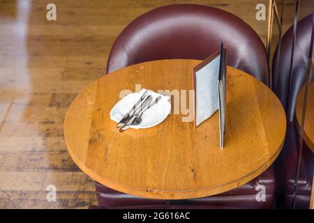En regardant par une fenêtre de restaurant une table et un ensemble de chaises vides pour le déjeuner, Royaume-Uni Banque D'Images