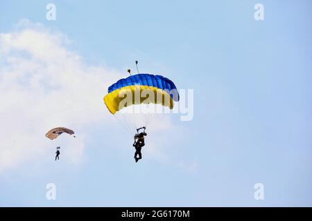 Non exclusif: MYKOLAIV, UKRAINE - 30 JUIN 2021 - des militaires descendent sur les parachutes qui font le drapeau ukrainien à l'aérodrome de Kulbakyne pendant Banque D'Images