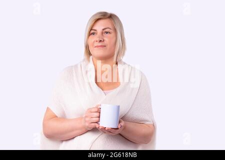 Portrait d'une belle femme vêtue d'un gilet blanc tenant une tasse de thé dans un salon de beauté soin de la peau. Banque D'Images