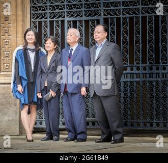 Une étudiante pose pour une photographie avec ses parents le jour de sa remise des diplômes à Gonville et Caius College, université de Cambridge, Angleterre. Banque D'Images