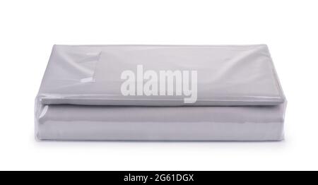 Draps de lit en coton gris pliés dans un sac en plastique transparent isolé sur du blanc Banque D'Images