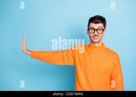Photo des dents négatives de jeune gars montrent le rejet de paume de bras vide espace isolé sur fond bleu Banque D'Images
