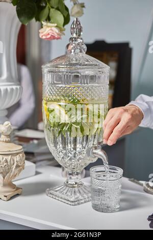 Un serveur de restauration verse une limonade sans alcool pour rencontrer des invités lors d'un mariage ou d'une fête d'anniversaire Banque D'Images