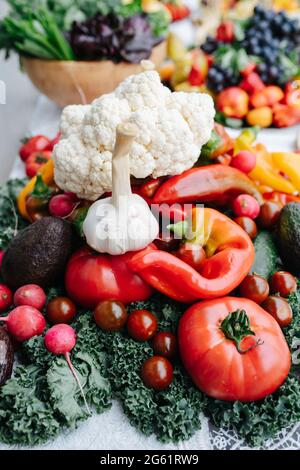 Montagne de légumes sur une table à manger luxuriante pour un événement. Tomates cerises, radis, etc Banque D'Images