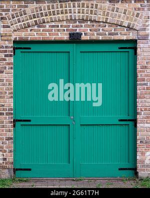 Portes fermées en bois turquoise entourées d'un mur de briques Banque D'Images