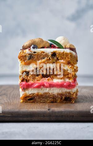 Magnifique gâteau épicé aux carottes avec deux garnitures : caramel et canneberge kurd. Génoise avec noix et épices et crème au fromage à la crème. Banque D'Images