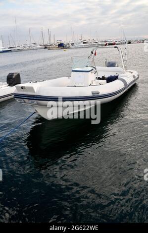 Bateau gonflable moderne avec moteur dans la mer près de la rive, bateau gonflable bleu blanc Banque D'Images