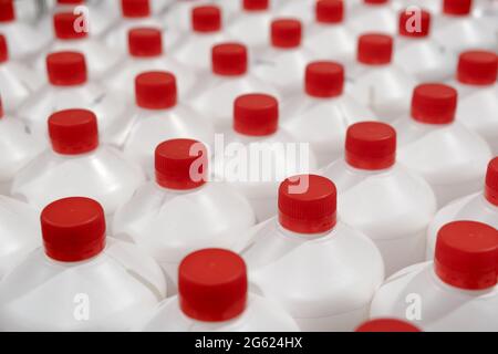 Bouteilles canettes plastique a rangées de produits chimiques ménagers professionnels recharge liquide dans le magasin de matériel d'entrepôt. Canisters en plastique blanc avec plasti rouge Banque D'Images