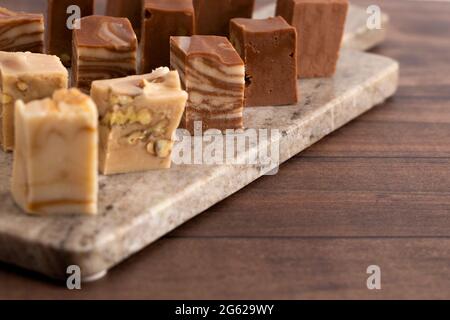 Six différentes saveurs de caramel sur une table en bois Banque D'Images