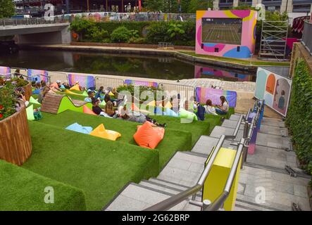 Londres, Royaume-Uni. 1er juillet 2021. On voit les gens regarder le championnat de tennis de Wimbledon sur un écran en plein air à Granary Square à King's Cross, Londres.Summer Love, un festival de cinéma en plein air gratuit des cinémas Everyman, présentera des films, ainsi que Wimbledon et Tour de France, Sur un grand écran extérieur tout au long de la journée et en soirée du 1er au 25 juillet 2021. Crédit : SOPA Images Limited/Alamy Live News Banque D'Images