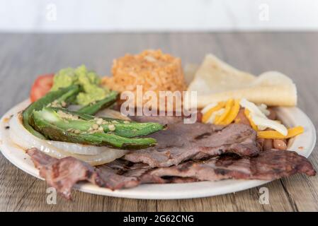 Viande de steak de carne asada grillée, chaude et servie avec du riz et des poivrons jalapeno cuits. Banque D'Images